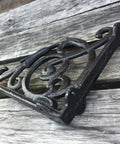 Rock Solid Cast Iron Shelf Brackets Heavy Duty Wall Mount Braces Vintage Metal Corbels in black on a wooden surface.
