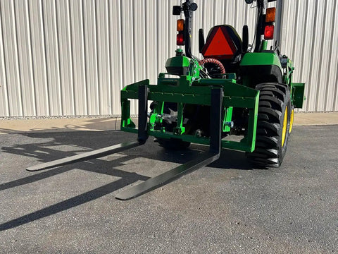 No Hassle Dual Mount Tractor Pallet Forks For Front Loader And Three Point Hitch featuring sturdy blades on a tractor.