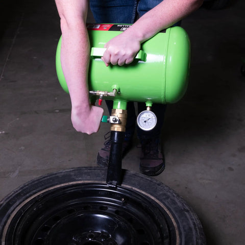 Person using a green 5 Gallon Tire Bead Seater And Bead Blaster For 4 To 24.5 Inch Tires 150 PSI Capacity CE Certified Steel Tank.