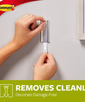 Hands using Large Universal Frame Hanger Set With 3 Hangers 6 Strips And 6 Frame Stabilizers For Damage Free Picture Hanging