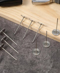 Extra Long Hardcore Upholstery Nails With Bulletproof Hold And Flat Head Furniture Tacks For Sofa Wood Trim Craft Projects Large Metal Push Pins Silver Finish Set on wood and gray fabric surface.