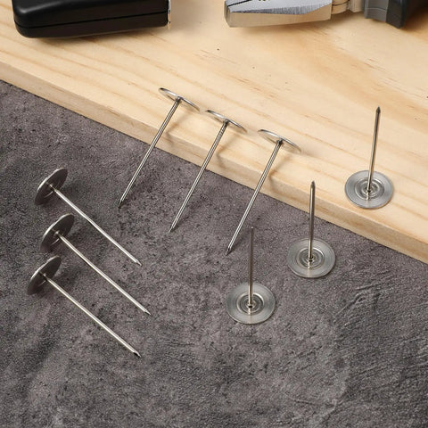 Extra Long Hardcore Upholstery Nails With Bulletproof Hold And Flat Head Furniture Tacks For Sofa Wood Trim Craft Projects Large Metal Push Pins Silver Finish Set on wood and gray fabric surface.