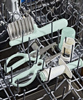 OXO Tot crinkle cutter with mint-green handle and stainless steel blade in a dishwasher with baby feeding tools.