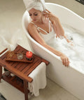 Premium Acacia Wood Toilet Tank Caddy And Vanity Tray Duo Ideal For Bathroom Clutter Control beside a bathtub with woman.