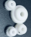 White POM gears including 0.8 Module 32 Teeth POM Gear 10mm Bore Plastic Spur Gear with straight teeth pinion on dark background.