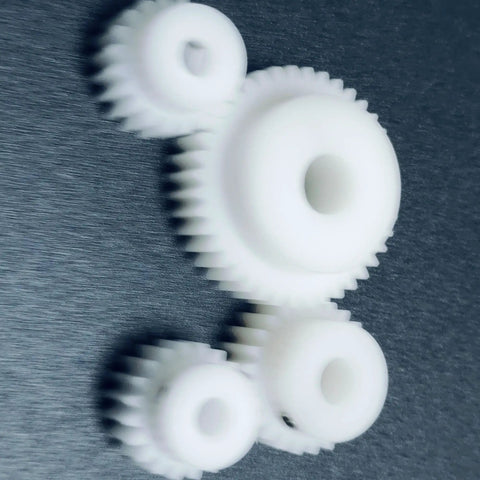 White POM gears including 0.8 Module 32 Teeth POM Gear 10mm Bore Plastic Spur Gear with straight teeth pinion on dark background.