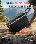 Massive 69 Quart 12V Portable Refrigerator And Freezer Cart Riding On Tough Off Road Wheels, showcasing sturdy handle and durability on rough terrain.