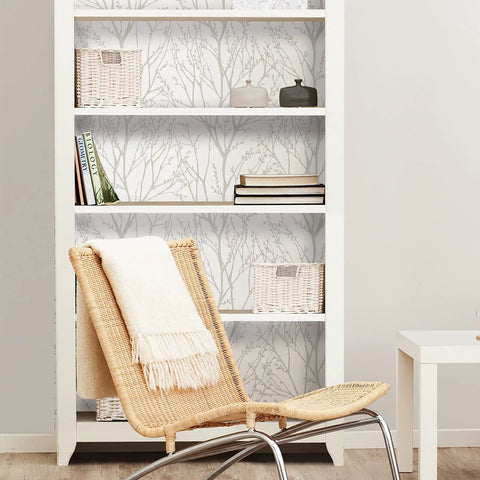 Room with a bookshelf and rattan chair against Treetops Peel And Stick Wallpaper In White And Off White, Removable Wall Covering