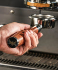 Level Up Your Home Barista Setup With This 58mm Bottomless Portafilter For Breville Dual Boiler Oracle Espresso Machine Rosewood Handle in hand.