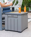 Versatile Outdoor Storage Cube Deck Box Doubles As Cozy Bench Seat And 25 Gallon Capacity Weather Resistant Patio Organizer, gray, with drinks and magazine.