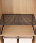 Heavy Duty Expandable Closet Shelf And Stackable Cabinet Organizer Set Black Adjustable Vertical Divider Rack on wooden shelf.