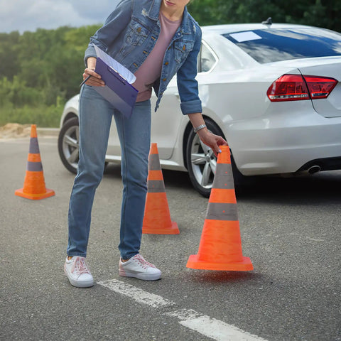 Person placing Four Pack 28 Inch Collapsible Traffic Cones With LED Light Reflective Collars Quick Pop Up Extendable Road Safety Cones beside car.