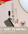 Small Brass Tone Metal Hooks With Adhesive Strips holding jewelry on wall. Damage Free Wall Hangers, No Tools Needed.