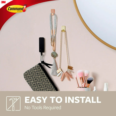 Small Brass Tone Metal Hooks With Adhesive Strips holding jewelry on wall. Damage Free Wall Hangers, No Tools Needed.
