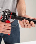 Person holding Extreme Duty 9 Inch Caulk Gun Workhorse with 26 to 1 Thrust Ratio and 950 lb Force, Revolving Barrel in hand