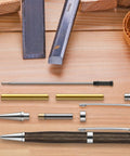 Knockout Twenty Piece 7Mm Slimline Twist Pen Kit With Shiny Silver Refills showing tools, parts, and finished pen on wood surface.