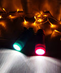 Two lit 9-LED mini flashlights from 18 Pack 9 LED Mini Flashlights With AAA Batteries Included And Pre Installed, glowing in the dark.