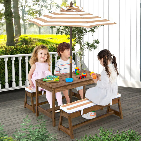 Children seated at Kid Approved Outdoor Picnic Table Set With Cushioned Benches, Adjustable Height Table, Built In Umbrella, Coffee Finish.