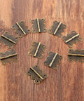 Mini Butterfly Door Hinge Set Antique Bronze 20 By 25mm 20 Pieces displayed on wooden surface