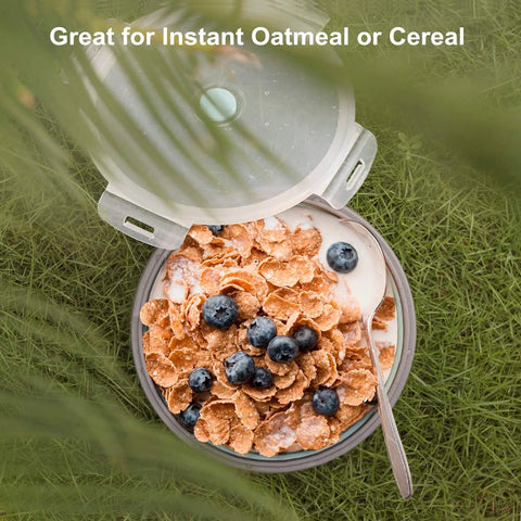 Aerial view of cornflakes with blueberries in a collapsible silicone camping bowl with airtight lid 1200ml on grass, with stainless fork.