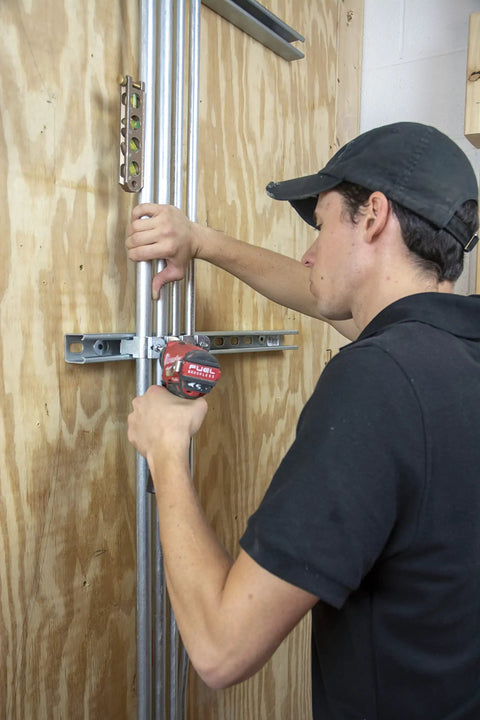 Person using a drill installing a Bulk Nail Plate One And A Half Inch By Two And A Half Inch Tough As Nails Durable Steel Connector