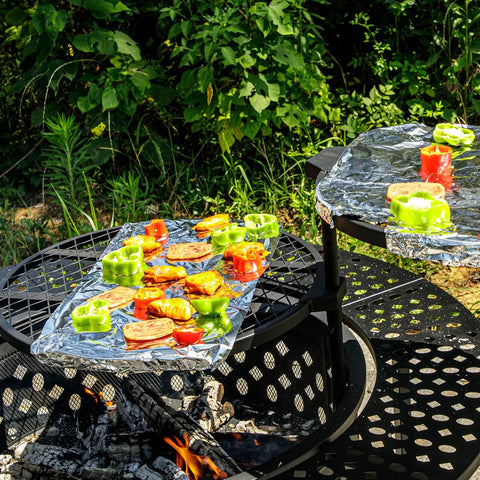 47 Inch Round Fire Pit With Two Grills, Lid And Tabletop, 3 In 1 Outdoor Fire Pit in use with vegetables cooking on grills