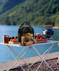 Desert Scorpion Eclipse Insulated Lunch Box on picnic table by lake with fruits and cooking pot, showcasing versatile outdoor use