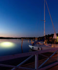 Sick Underwater Led Dock Light With Heavy Duty Fish Attraction Glow No Sweat Plug And Play Install Low Voltage Marine Safety And A Forty Foot Cord That Shines With Straight Fire Brightness For Night Fishing illuminating water near dock at dusk.
