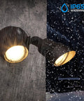 Adjustable Dual Head Dusk To Dawn Outdoor Security Light with Photocell illuminating snow, bronze aluminum housing visible