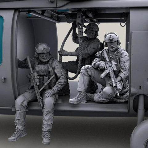 Three soldiers with rifles seated on a helicopter model from a 1/35 Scale US Commando Resin Figure Kit With Seven Soldiers, Two Machine Guns And Rope.