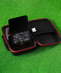 SC4 Portable Launch Monitor Pouch With Protective Hard Carry Case open on grass showing inner compartments and electronic screen.