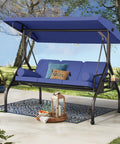 Three In One Outdoor Porch Swing Bed With Canopy Three Seat Patio Glider in dark blue set up on a porch with cushions.
