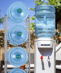 5 Tier Water Jug Stand Storage Rack For Five Gallon Jugs Detachable Heavy Duty Water Dispenser Shelf next to cooler outdoors