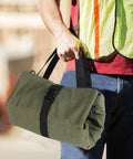 Person carrying Sturdy Canvas 16oz Tool Roll Up Bag For Wrenches And Tools, Grab And Go Multi Purpose Organizer with Five Zipper Pockets.