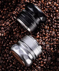 Top Shelf 4 Piece Espresso Kit Featuring Adjustable Height Spring Coffee Tamper For 58mm Portafilter with two coffee tampers on coffee beans.