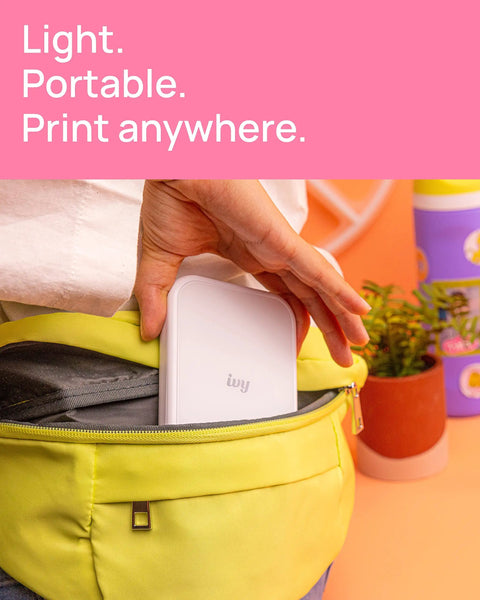 Person placing Ivy 2 Mini Photo Printer For IPhone And Android Zero Ink ZINK Tech Print Sticky Back Photos Directly From Your Smartphone On The Go No Ink Needed Quick Colorful Prints In Pure White Finish into yellow bag