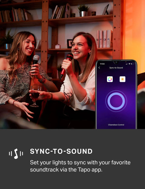 Two women singing karaoke with RGB LED Light Strip With Music Sync, 32.8ft Of Colorful Ambiance controlled via Tapo app on smartphone.