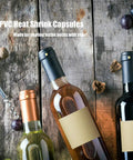 Premium PVC Heat Shrink Wine Bottle Capsules 120 Count Black Red Gold Cork Seal Wrap For Cellars And Home Wineries on a wooden surface