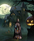 Person wearing Halloween Adult Hooded Cape With Full Body Transfer Print standing in front of a haunted house at night.