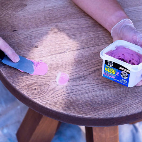 Killer Hold Smooth As Butter Stainable Wood Filler With Smart Pink To Gray Drydex Indicator being applied on wood surface using a putty knife.