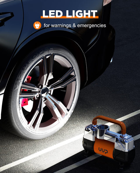 Beefy Heavy Duty 12V DC Double Cylinder Tire Inflator Air Compressor With LED next to a car tire at night
