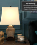 Tall Porcelain Lantern Table Lamp With Black And Brown Ming Medallion Design, displayed on a wooden desk, complementing decor