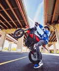 Person performing wheelie on Gnarly 2600W Mid-Drive Electric Dirt Bike For Teens And Adults Up To 40 MPH With 23.4Ah 48V Battery