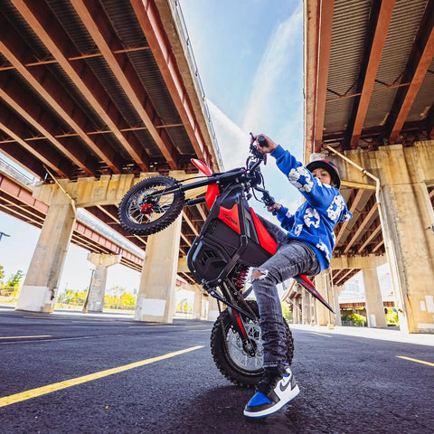 Person performing wheelie on Gnarly 2600W Mid-Drive Electric Dirt Bike For Teens And Adults Up To 40 MPH With 23.4Ah 48V Battery