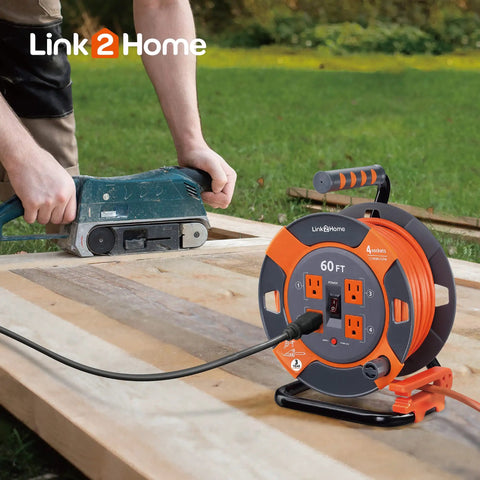 60 Ft Cord Reel With Four Outlets 14 AWG SJTW Cable Workhorse Heavy Duty shown on a wooden workbench with a power tool.
