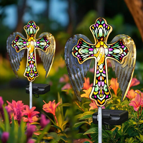 Solar Glass Cross Garden Stake Light With Angel Wings And Stained Glass Look placed among blooming flowers in garden