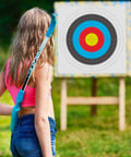 Person holding a bow in front of a Bulk 30 Pack Archery Target Paper 40x40cm 10 Ring Indoor Target Faces on a stand outdoors.