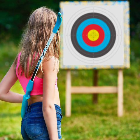 Person holding a bow in front of a Bulk 30 Pack Archery Target Paper 40x40cm 10 Ring Indoor Target Faces on a stand outdoors.