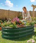 Sturdy Galvanized Steel Raised Garden Bed With 12 Inch Depth Oval Open Bottom Design Yard Ready No Fuss For Outdoor Veggies And Herbs 4X2 Foot Frame Easy Ground Level Gardening Forest Green shown outdoors with plants