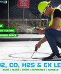 Technician using 4 Gas Monitor With Built In Pump And Probe for O2, CO, H2S, LEL detection near confined space entry.